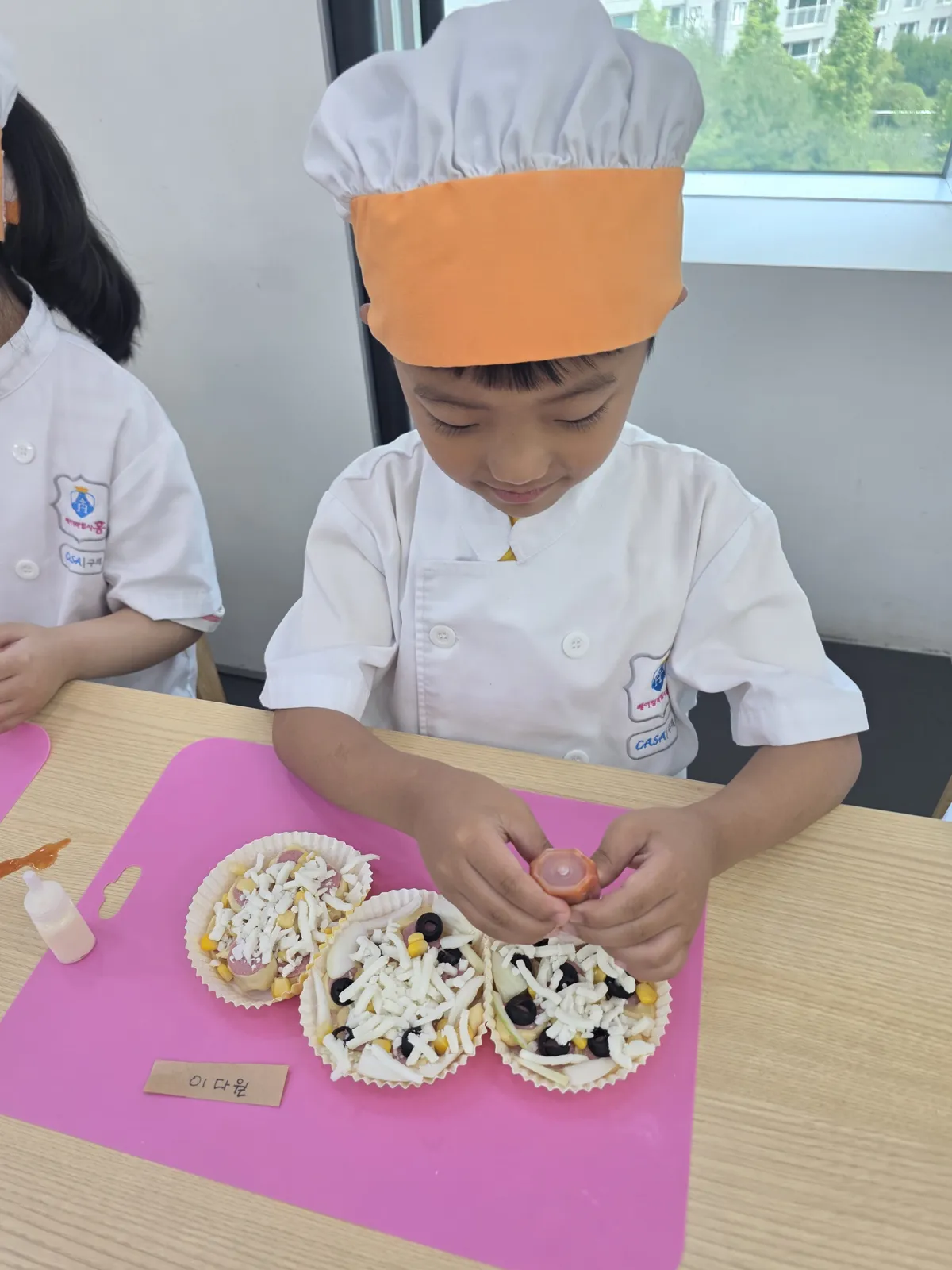 요리사 모자를 쓰고 요리하는 아이