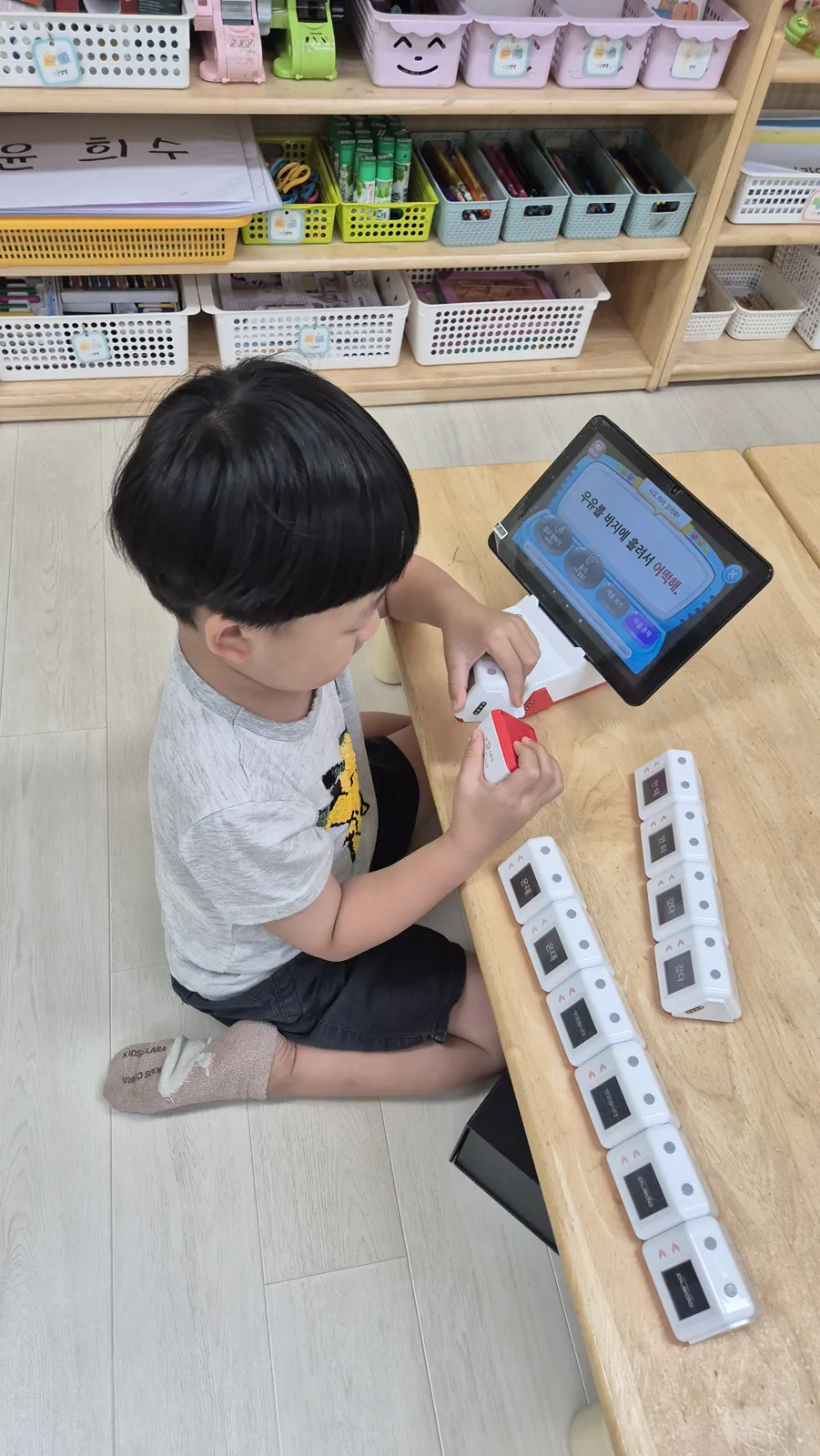 태블릿과 블록으로 코딩 놀이를 하는 아이